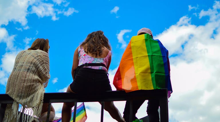 A vibrant scene of unity and pride with diverse individuals enjoying a sunny day together.